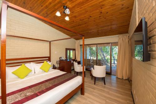 - une chambre avec un lit, une table et des chaises dans l'établissement Kambiri Beach by Serendib, à Senga