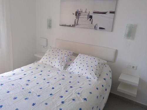 1 cama en un dormitorio blanco con una foto en la pared en Luz Azul, en Costa Calma