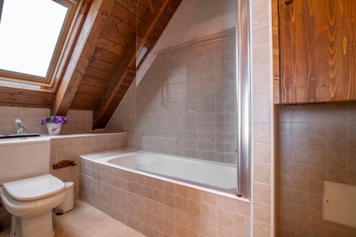 a bathroom with a bath tub and a toilet at TAMARRO de Alma de Nieve in Baqueira-Beret