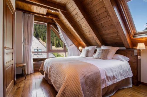 a bedroom with a bed and a large window at TAMARRO de Alma de Nieve in Baqueira-Beret