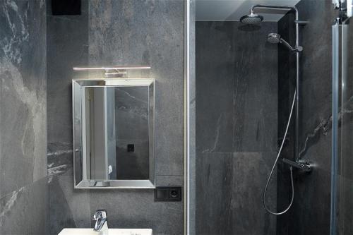 a bathroom with a shower and a sink and a mirror at Найгарніша квартира в Черкасах! in Cherkasy