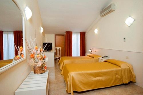 Pokój hotelowy z 2 łóżkami i lustrem w obiekcie Hotel Massimino w mieście Anguillara Sabazia