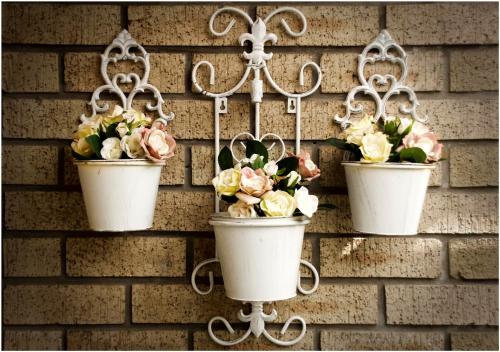 three flower pots hanging on a brick wall at Villa Rose Cottages in Bloemfontein