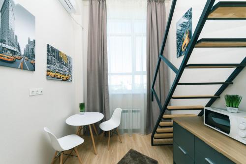ein kleines Zimmer mit einer Treppe, einem Tisch und Stühlen in der Unterkunft My SmartApart Hotel Today in Kiew