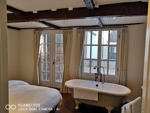 a bathroom with a bath tub next to a bed at Entire House In Centre of Ghent in Ghent