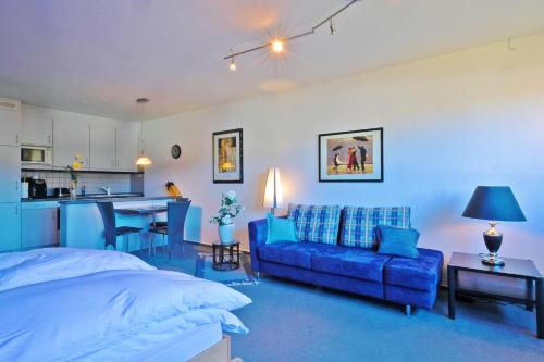 ein Schlafzimmer mit einem blauen Bett und einem blauen Sofa in der Unterkunft Goski & Gobike Winterberg Netflix and WaipuTV free in Winterberg