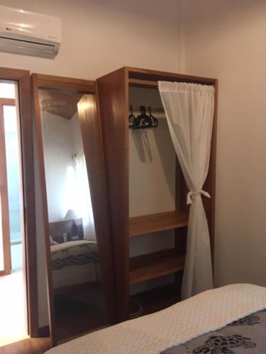 a bedroom with a dresser with a mirror and a bed at Praia do Forte Apartamento Fantástico in Praia do Forte