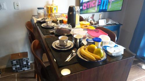 una mesa con plátanos y otros alimentos. en Hospedom Mazzoca 01, WC compartilhado, en Itapema