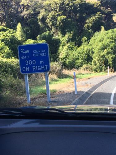 a blue sign on the side of a road at Hideaway - A Couples Retreat in Akaroa