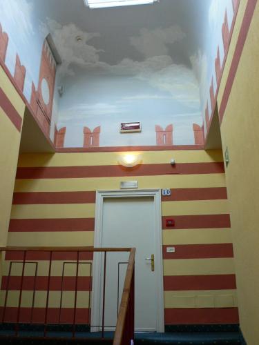 a hallway with red and orange striped walls and a door at Hotel Alla Riviera in Bardolino