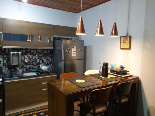 a kitchen with a table with chairs and a refrigerator at Hospedom Mazzoca 02 , WC compartilhado in Itapema