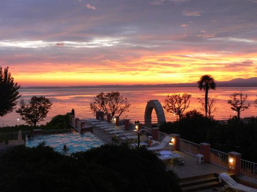 a pool with a view of the ocean at sunset at Hotel Alla Riviera in Bardolino