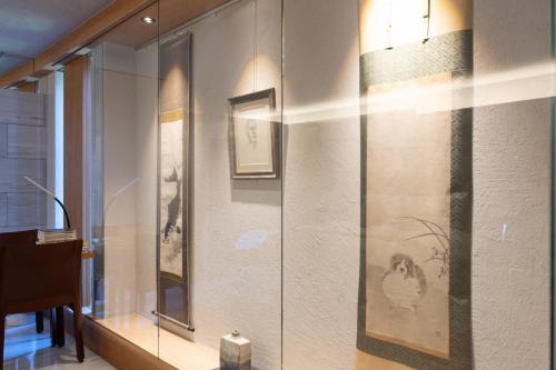 a glass display case in a room with pictures on the wall at Luxury Condo Shikine An Gion Shirakawa in Kyoto
