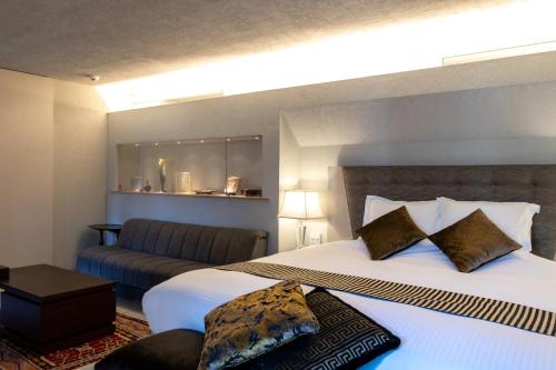 a hotel room with two beds and a couch at Luxury Condo Shikine An Gion Shirakawa in Kyoto