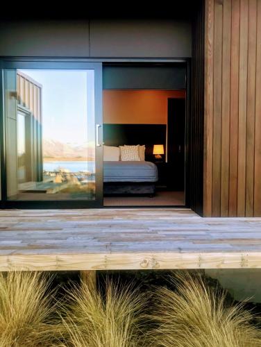 a bedroom with a bed seen through a glass door at The View Lake Tekapo in Lake Tekapo
