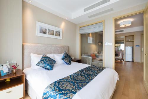 a bedroom with a large white bed with blue pillows at Pinxiayuan Apartment in Lvcheng Resort in Zhoushan
