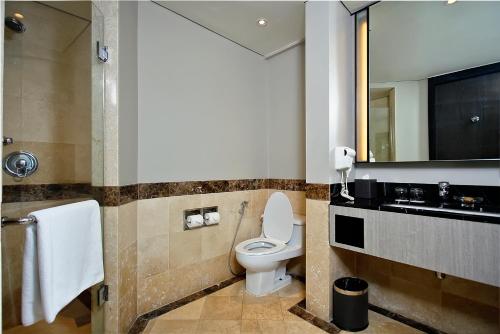 a bathroom with a toilet and a sink and a mirror at The Pacific Sutera Hotel in Kota Kinabalu