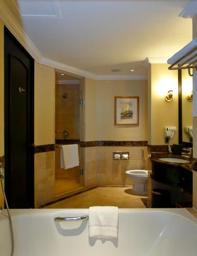 a bathroom with a tub and a toilet and a sink at The Pacific Sutera Hotel in Kota Kinabalu