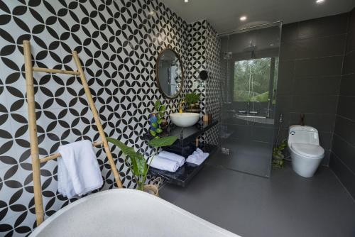 a bathroom with a black and white patterned wall at G Boutique Retreat Hoi An in Hoi An