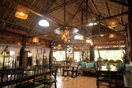 a restaurant with tables and chairs in a room at Villa Khadine Grand Vista Resort in Coron