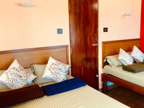 a bedroom with two beds and a door to a room at Mermaid Island Beach Resorts in Puducherry