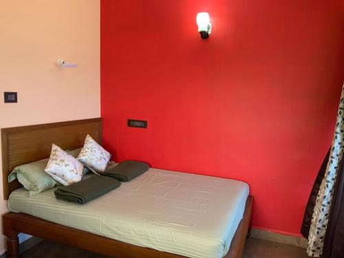 a bedroom with a red wall and a bed at Mermaid Island Beach Resorts in Puducherry