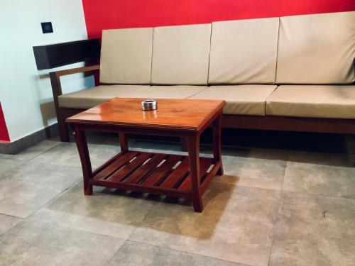a wooden coffee table in front of a couch at Mermaid Island Beach Resorts in Puducherry