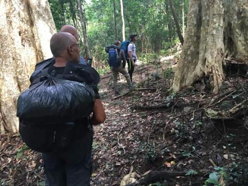 a group of people walking on a trail in the woods at Tribal Village Homestay & Trekking in Banlung