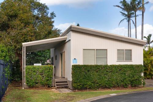 a white house with a gate and trees at Discovery Parks - Ballina in Ballina