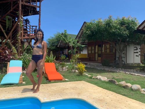 a woman in a bikini standing next to a pool at Nubá Boutique Hostel Palomino in Palomino