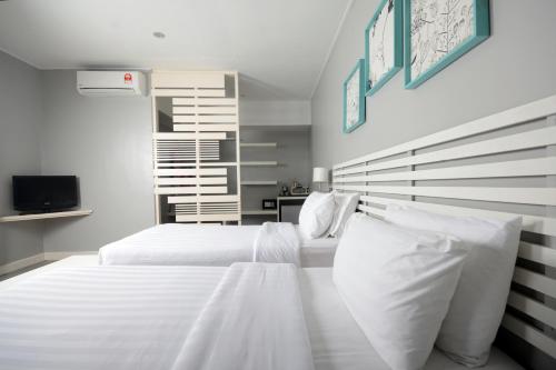 a bedroom with two beds with white pillows at La Pari-Pari in Pantai Cenang