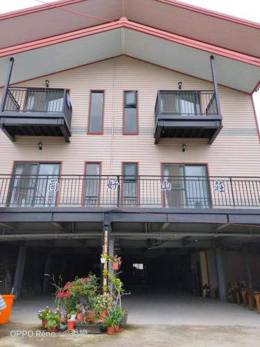 a building with balconies and flowers in front of it at 崗好山莊 in Jianshi
