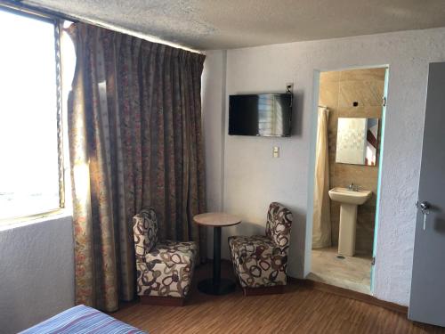 une chambre d'hôtel avec une table, des chaises et un miroir dans l'établissement Hotel Aquario, à Mexico