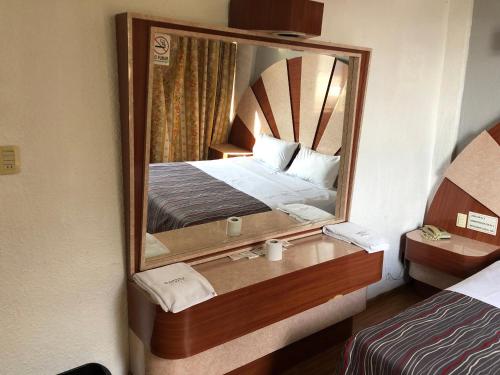 Habitación de hotel con cama y espejo en Hotel Aquario en Ciudad de México