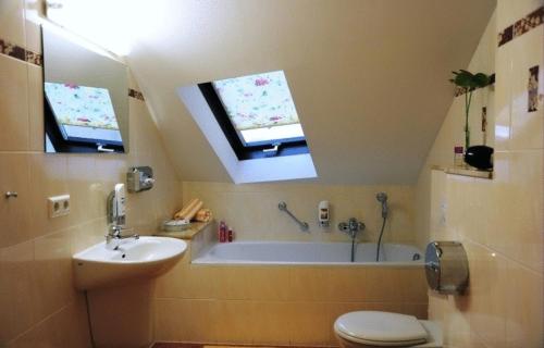 a bathroom with a tub and a toilet and a sink at Hotel-Pension Am Schwanenteich in Lutherstadt Wittenberg
