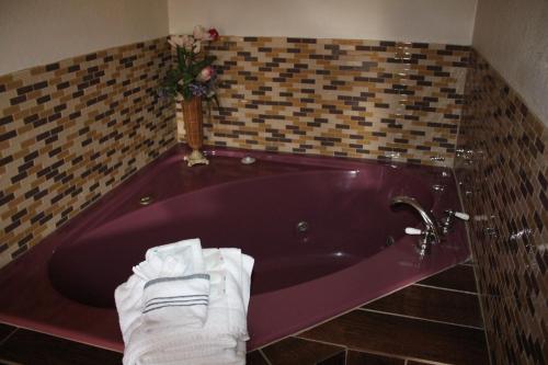 a purple bath tub with towels in a bathroom at Economy Inn - Statesville in Statesville