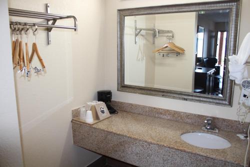 a bathroom with a sink and a mirror at Economy Inn - Statesville in Statesville
