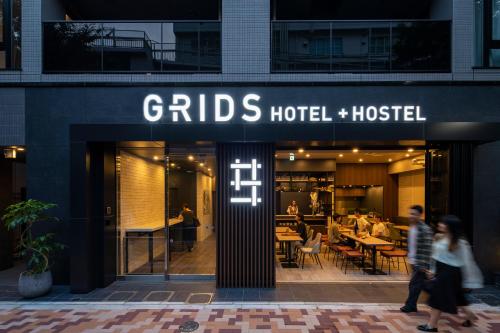 a group of people walking in front of a hotel at Grids Tokyo Ueno Hotel&Hostel in Tokyo