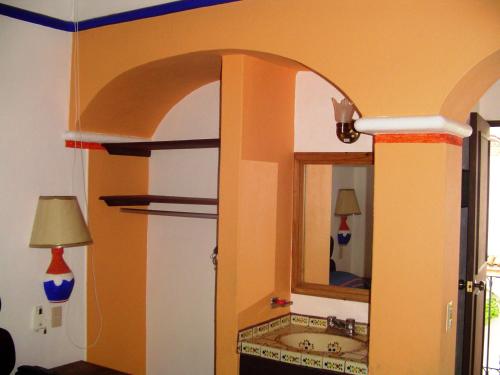 W łazience znajduje się umywalka i lustro. w obiekcie Hotel & Suites Coral w mieście Puerto Vallarta