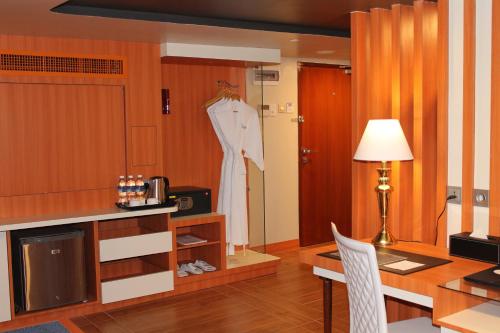 a room with a table and a dress hanging on a door at Doulos Phos The Ship Hotel in Lagoi