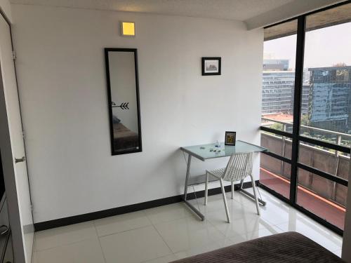 a table and chair in a room with a window at Caravansaro Penthouse Polanco in Mexico City