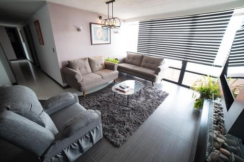 a living room with two couches and a rug at Caravansaro Penthouse Polanco in Mexico City