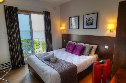 een slaapkamer met een groot bed met paarse kussens bij Carlton Hotel in Sliema