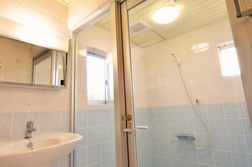 a bathroom with a shower and a sink at Purple House in Chatan