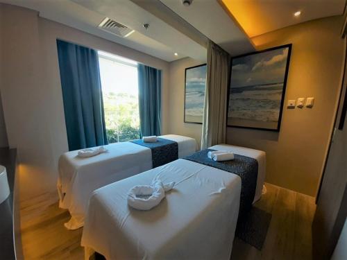 a hotel room with two beds and a window at Belmont Hotel Boracay near Newcoast Beach in Boracay