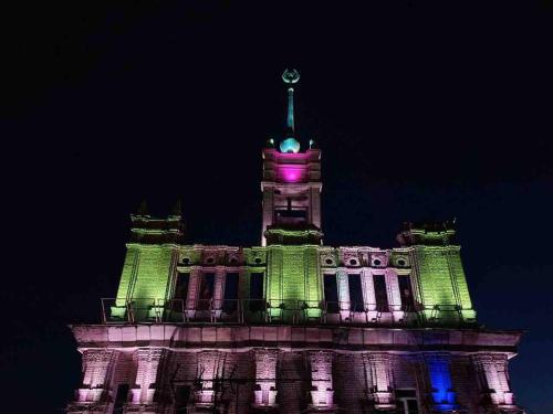 a building with a clock tower at night at Уникальный двухуровневый пентхаус с террасой (центр) in Kharkiv