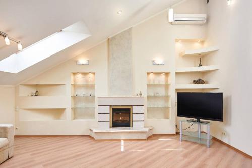 a living room with a fireplace and a flat screen tv at Уникальный двухуровневый пентхаус с террасой (центр) in Kharkiv