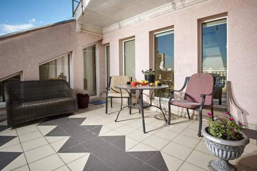 a patio with a table and chairs on a balcony at Уникальный двухуровневый пентхаус с террасой (центр) in Kharkiv