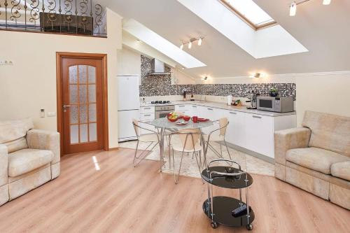 a kitchen and living room with a table and chairs at Уникальный двухуровневый пентхаус с террасой (центр) in Kharkiv