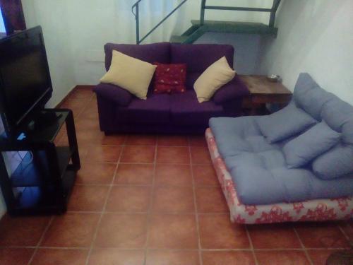 sala de estar con sofá púrpura y mesa en El Mirador de la Desembocadura, en Ayamonte